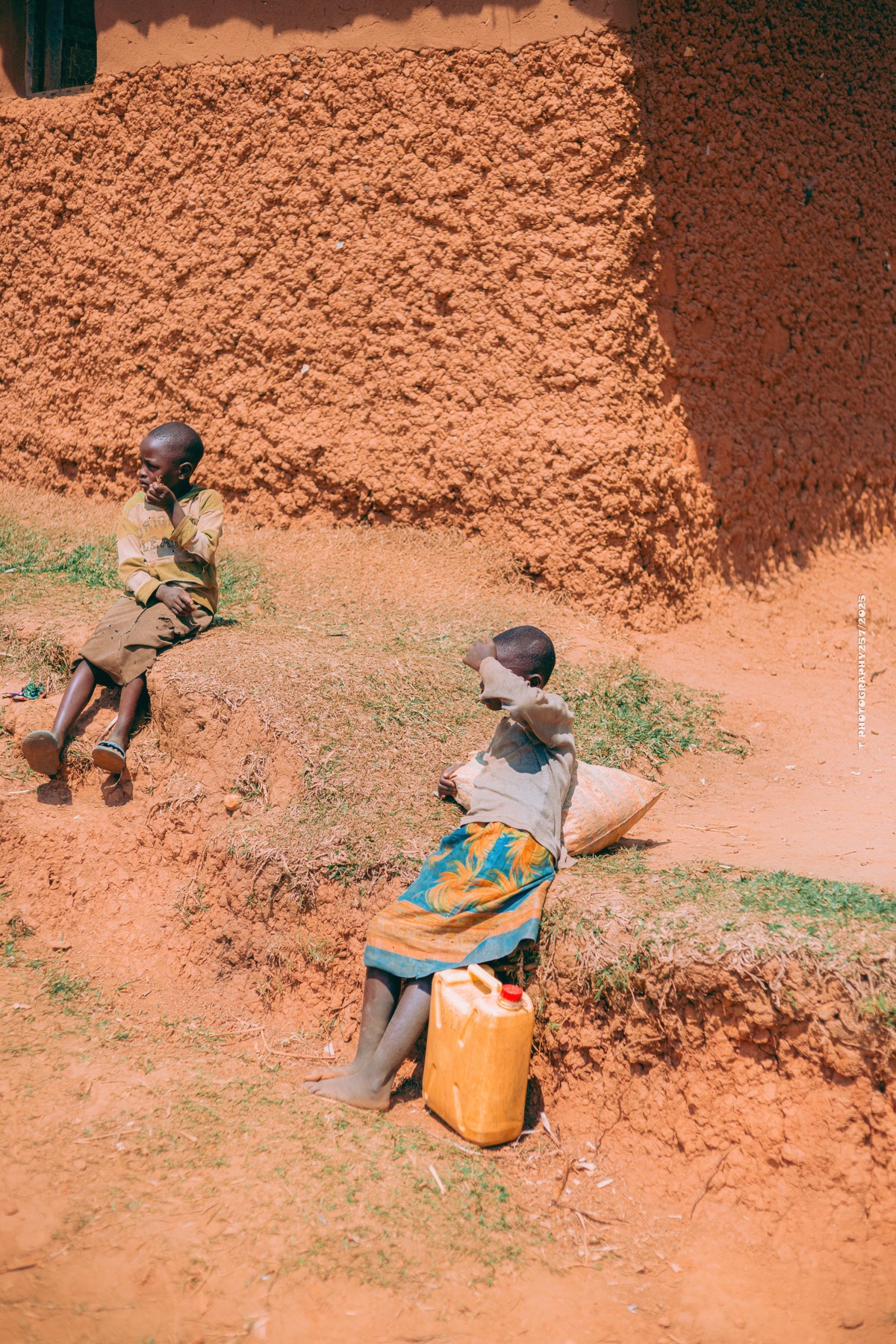 Two children seated outside a home in Burundi